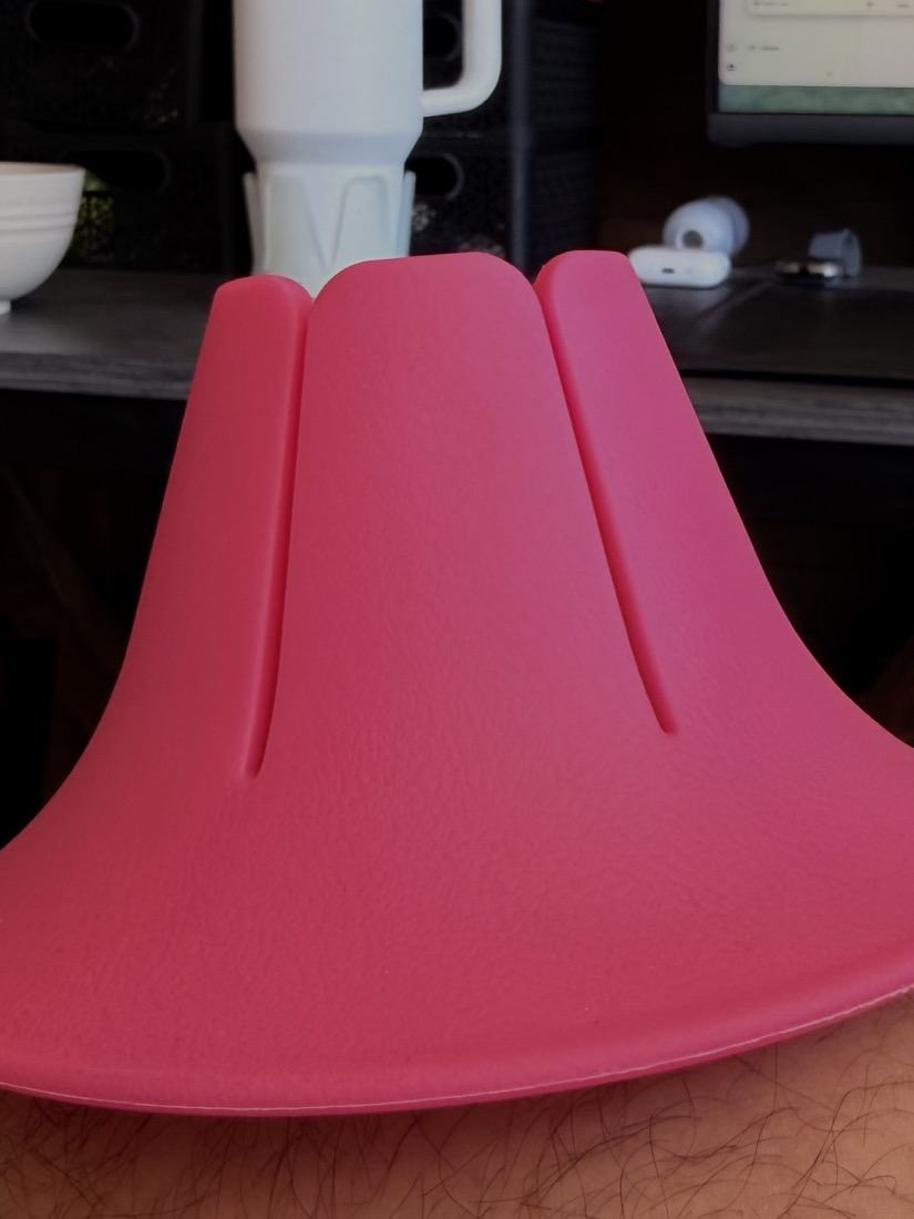 A Rose coloured Steadi on a table, seen from the side: a low flared base rising to a fluted opening.